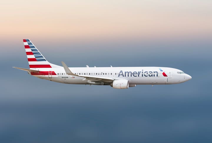 An American Airlines jet in flight above the clouds