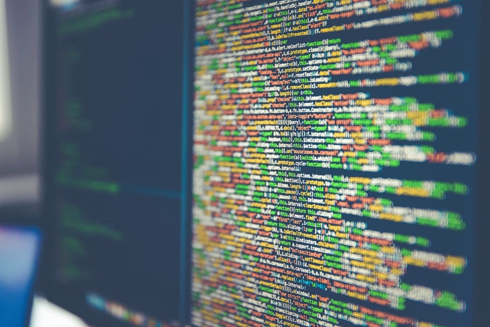 Lines of source code on a computer monitor, representing the digital trail behind coordinated stock manipulation