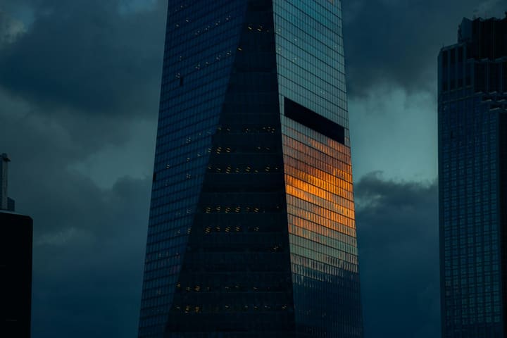 Dark glass skyscrapers rising into a stormy sky